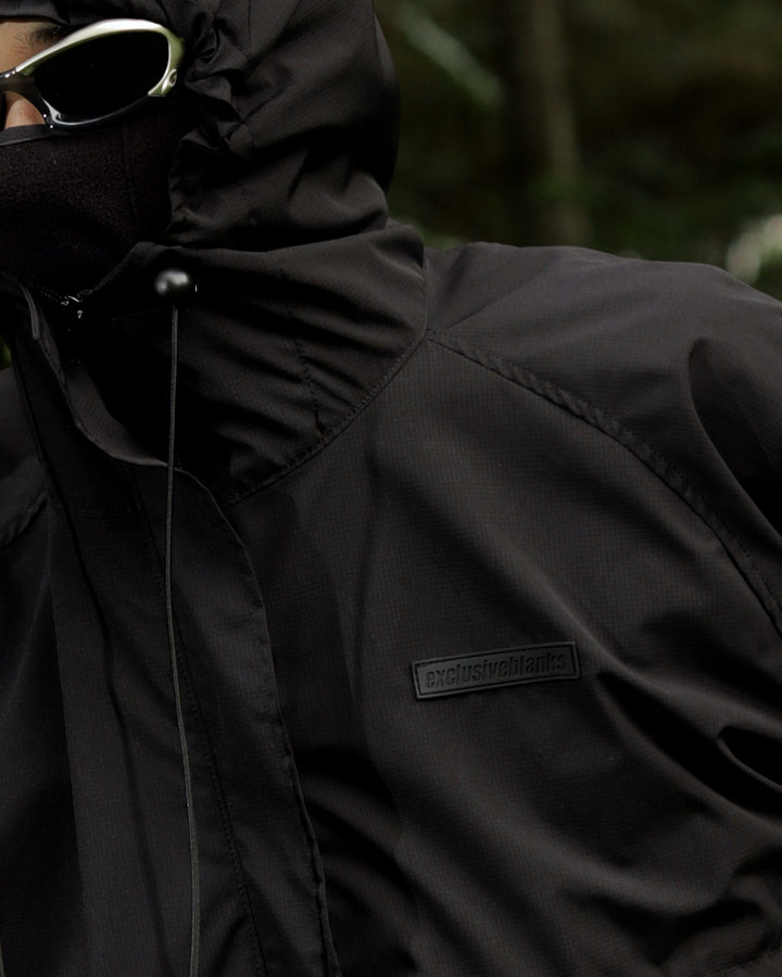 Close-up of a black jacket with a brand logo on a dark background